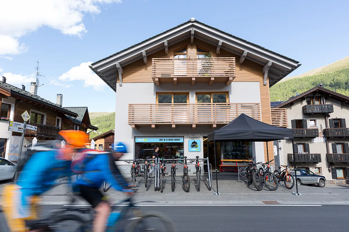 A cyclist rides past the Skialo San Rocco shop